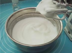 用打蛋器将蛋清打至中性发泡，提起打蛋器蛋白呈现出有弧度的长尖锥角。