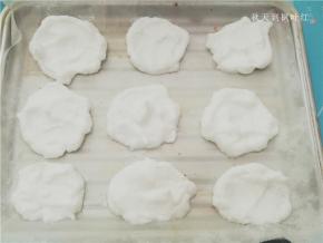 用小勺取适量蛋白放入铺好油纸的烤盘中；