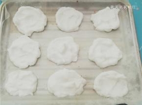 用小勺取适量蛋白放入铺好油纸的烤盘中；