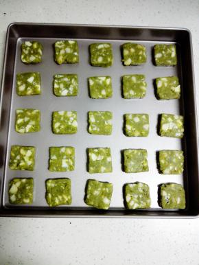 冻好的饼干团取出，切成0.5cm的片状，放入烤盘