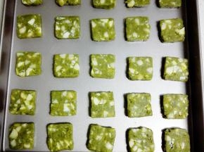 冻好的饼干团取出，切成0.5cm的片状，放入烤盘