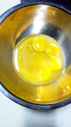 蛋白和蛋黄分离在两个无水无油的盆中，蛋黄中加入橙汁，柠檬汁，玉米油搅打均匀