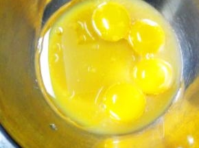 蛋白和蛋黄分离在两个无水无油的盆中，蛋黄中加入橙汁，柠檬汁，玉米油搅打均匀