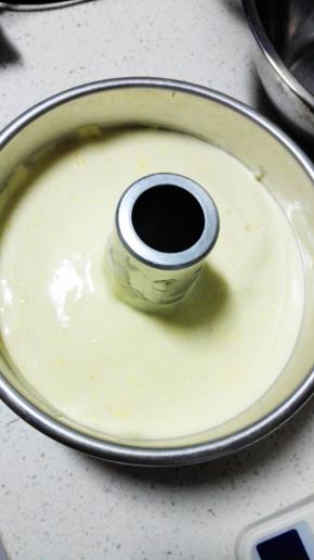 将拌匀的蛋糕糊倒入模具中，表面抹平后，提起模具在桌面上振三下，振出大气泡