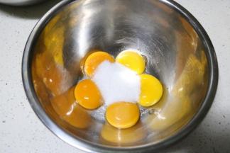 将蛋白和蛋黄分离在两个无水无油的盆中， 蛋黄中加入30克细砂糖用打蛋器打至颜色变浅