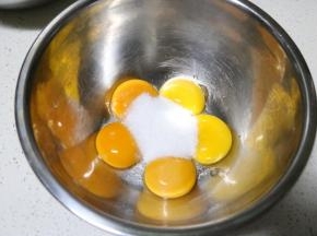 将蛋白和蛋黄分离在两个无水无油的盆中， 蛋黄中加入30克细砂糖用打蛋器打至颜色变浅