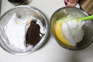 将蛋白霜分成两份，倒入两份蛋黄糊中