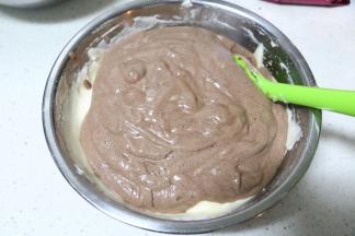 将可可色的蛋糕糊倒入原味蛋糕糊中，用刮刀搅拌两下，此时烤箱可150度预热