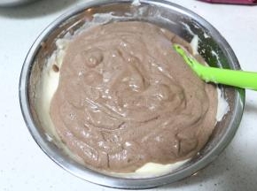 将可可色的蛋糕糊倒入原味蛋糕糊中，用刮刀搅拌两下，此时烤箱可150度预热