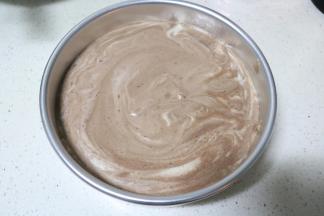 将蛋糕糊倒入模具中，提起模具在桌子上振三下，振出大气泡