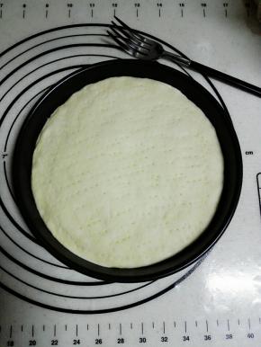 将面皮放入8寸披萨盘中，用叉子在表面戳洞