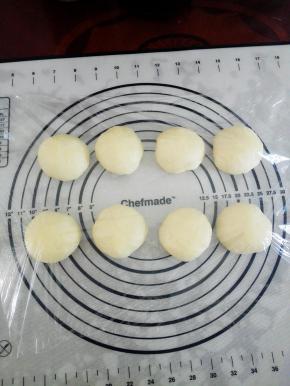 取出发酵好的面团，揉匀后，分成8个大小均匀的面团，揉圆后，盖上保鲜膜，静置15分钟