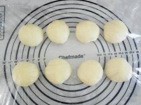 取出发酵好的面团，揉匀后，分成8个大小均匀的面团，揉圆后，盖上保鲜膜，静置15分钟