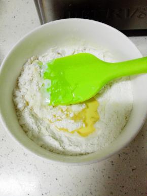 低粉过筛，依次加入牛奶和玉米油，搅拌均匀