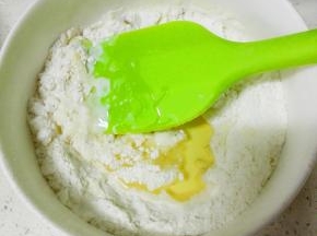 低粉过筛，依次加入牛奶和玉米油，搅拌均匀