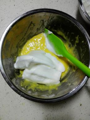 此时烤箱180预热，
取三分之一蛋白入蛋黄糊中，翻拌均匀