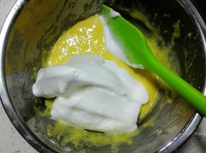 此时烤箱180预热，
取三分之一蛋白入蛋黄糊中，翻拌均匀