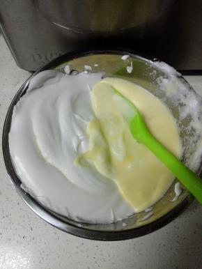 然后将蛋白全部倒入蛋黄糊盆中，翻拌均匀