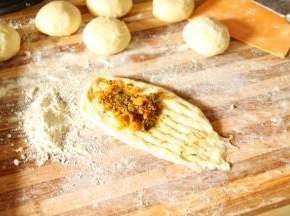 在头部包入一份肉松香葱馅 尾部三分之一用快一点的刀片割出条 割头  面团从头部整理出梭形  尾部压好收紧 放入模具 没有模具 直接放在烤盘上也可以 二发至两倍大