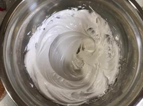 煮好的糖浆分多次倒入蛋清，打蛋器高速打发，糖浆倒完后中速继续打，直到手触摸打蛋盆不在烫手，停止打发。蛋白霜坚挺有光泽。