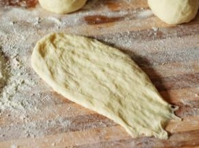 取一个面团擀成长条 尾部压扁