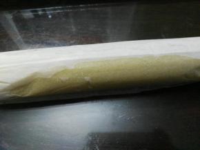 用擀面杖将曲奇卷起。把擀面杖放在油纸下面，卷起曲奇卷的一头，用擀面杖带着油纸提起后向下压着卷曲奇，一边压，一边把油纸卷在擀面杖上，就是曲奇卷向前卷，油纸向后卷；卷好的曲奇用油纸包好，放进冰箱冷冻30分钟