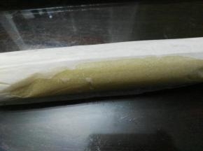 用擀面杖将曲奇卷起。把擀面杖放在油纸下面，卷起曲奇卷的一头，用擀面杖带着油纸提起后向下压着卷曲奇，一边压，一边把油纸卷在擀面杖上，就是曲奇卷向前卷，油纸向后卷；卷好的曲奇用油纸包好，放进冰箱冷冻30分钟