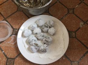 然后放在生粉碟中轻轻滚动，使鱼丸表面裹上一层薄薄的生粉