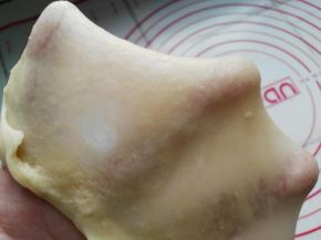 面团大概要揉到扩展阶段，即图中可以用手撑开大片薄膜即可