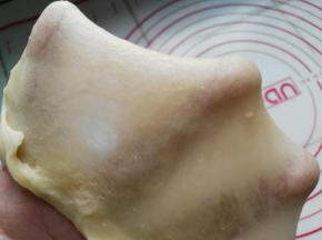 面团大概要揉到扩展阶段，即图中可以用手撑开大片薄膜即可