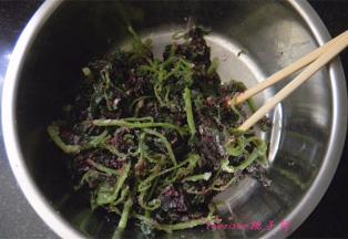 把蒸好的茼蒿放在盆子里，趁热用筷子挑散，因为拌了油，所以很容易就挑开了。