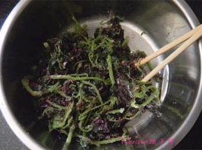 把蒸好的茼蒿放在盆子里，趁热用筷子挑散，因为拌了油，所以很容易就挑开了。