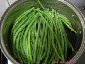 豇豆摘洗干净切大段放煮锅里焯烫熟，捞出来过凉水；