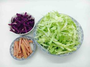 把圆白菜、紫甘蓝、火腿肠切成筷子粗细的丝，