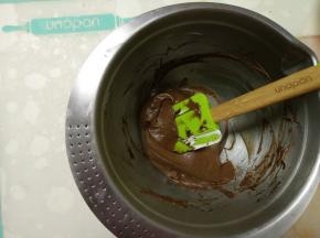 取些打发好的淡奶油到黑巧克力酱中拌匀。