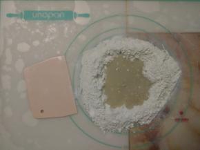 粉和糖等倒入揉面垫上，中间扒窝，倒入水和酵母混合液。