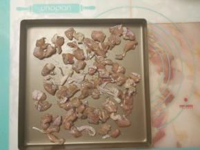 趁着发酵的时间，做好其它准备工作。首先把腌制好的鸡腿肉平铺在烤盘上。