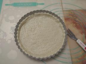 整个派盘均匀抹一层黄油，状擀好的圆饼铺在派盘上，用手掌按压，使面团和模具完全贴合，并用叉子在面皮上叉些小孔。