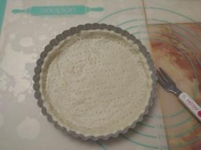 整个派盘均匀抹一层黄油，状擀好的圆饼铺在派盘上，用手掌按压，使面团和模具完全贴合，并用叉子在面皮上叉些小孔。