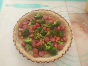 把拌匀的脆皮肠和蔬菜倒入派皮里。