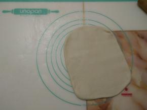 取出冷冻的面团，用擀面杖擀开，翻面继续擀开成长方形。