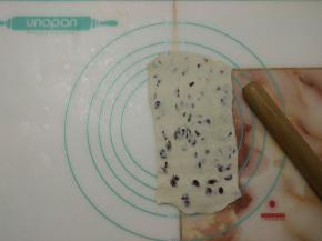 取出冷冻好的面团，纵向摆放，用擀面杖稍微擀薄。