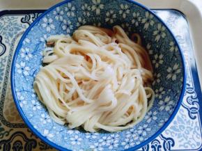 首先将煮熟的面用筷子夹到碗里。再盛入鸡蛋，摆上熟的牛肉。盛入汤汁。