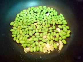 锅中加入适量油，加入蒜末煸炒，炒出香味，加入毛豆煸炒。