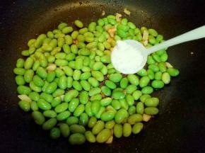 毛豆炒至外皮打皱时加入盐，糖。