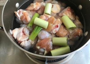 准备一锅凉水，放入洗干净的鸡翅段，放入葱，开小火，把鸡翅焯水