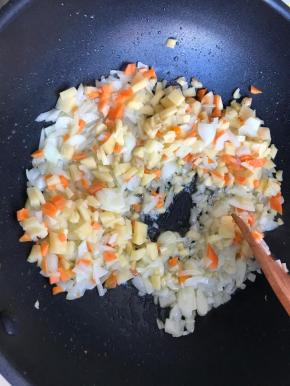 炒软后加入土豆胡萝卜丁，继续炒两分钟