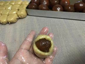 然后面团包裹馅球，包好，按扁，放好馅，利用虎口慢慢往上推，收口，这样包裹比较均匀。