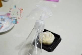 准备一个喷壶，喷雾要细。距离和果子大约20cm的水平位置，喷1-2下，让喷出的水雾自然下落在和果子表面。