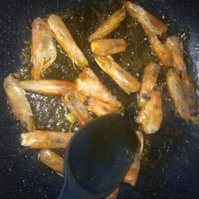 锅内倒入适量食用油，放入虾头，小火一边煎炸，一边用铲子按压虾头，直到油变成红色，虾头干瘪。
